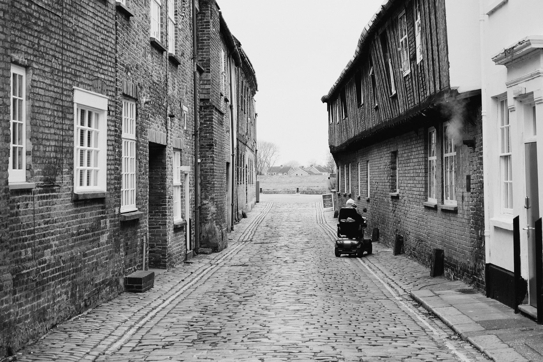 Electric wheelchair on a cobbled street for Stavanger surface planning.