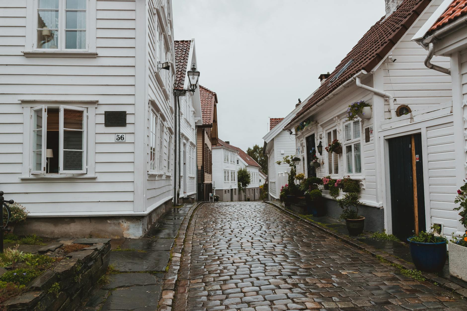 Narrow wet street for Stavanger woman traveler hotel-base planning.