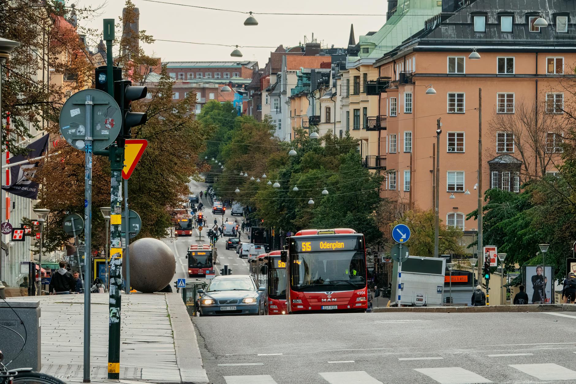 Buses and pedestrians in Sodermalm for Stockholm budget transit planning.