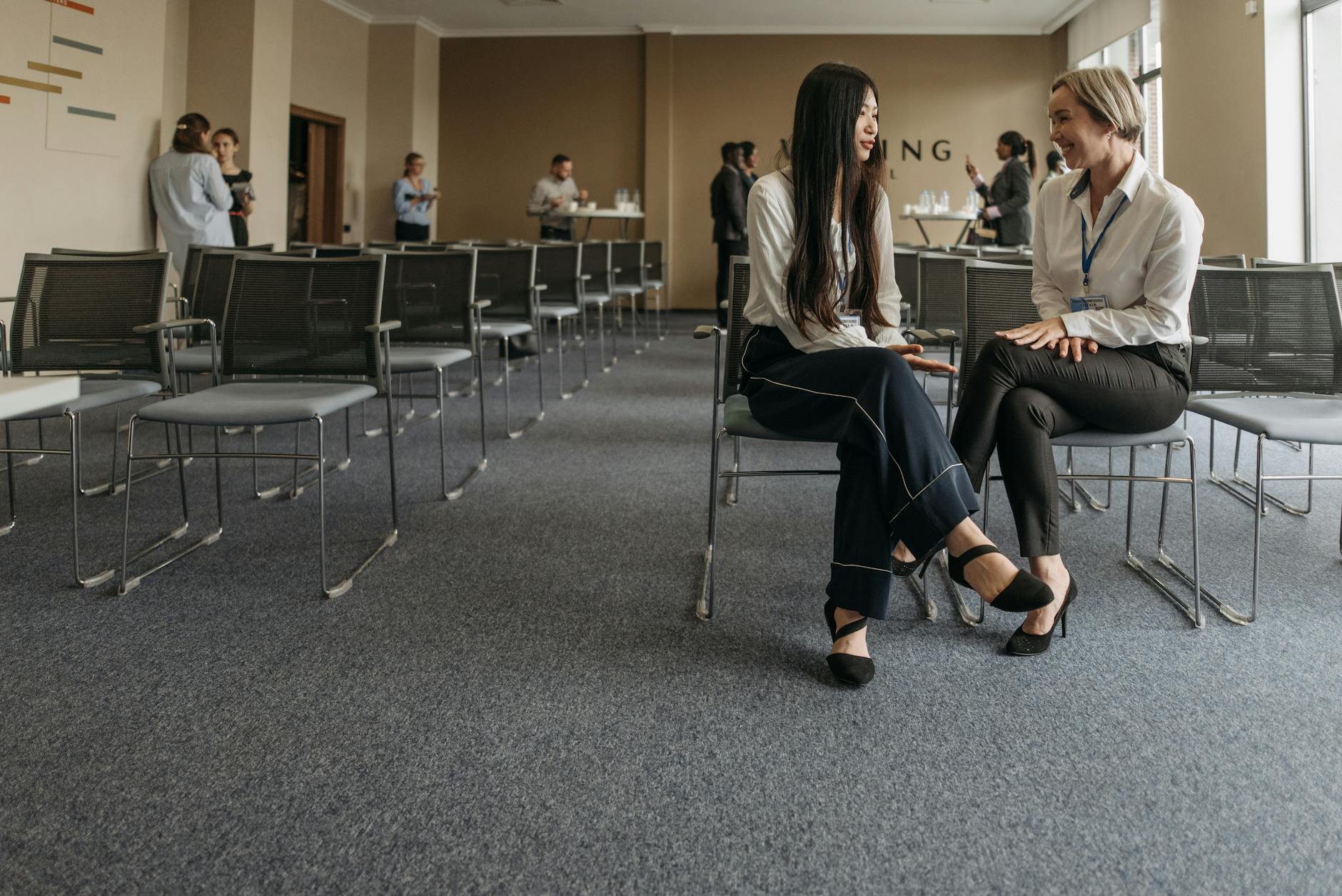 Professionals speaking during a conference break for hotel rhythm planning.