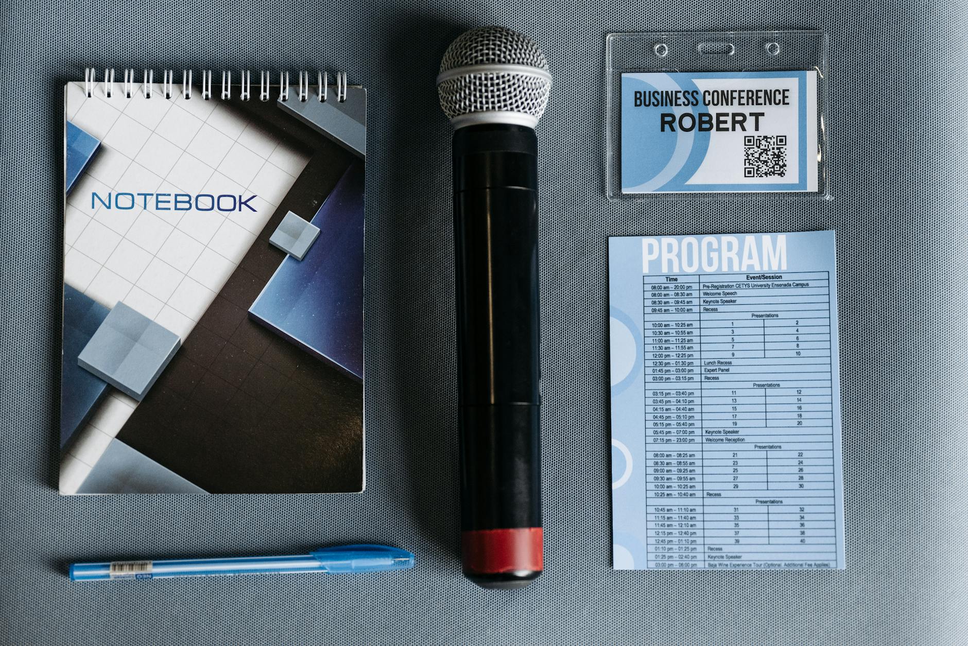 Conference materials with microphone and badge for registration planning.