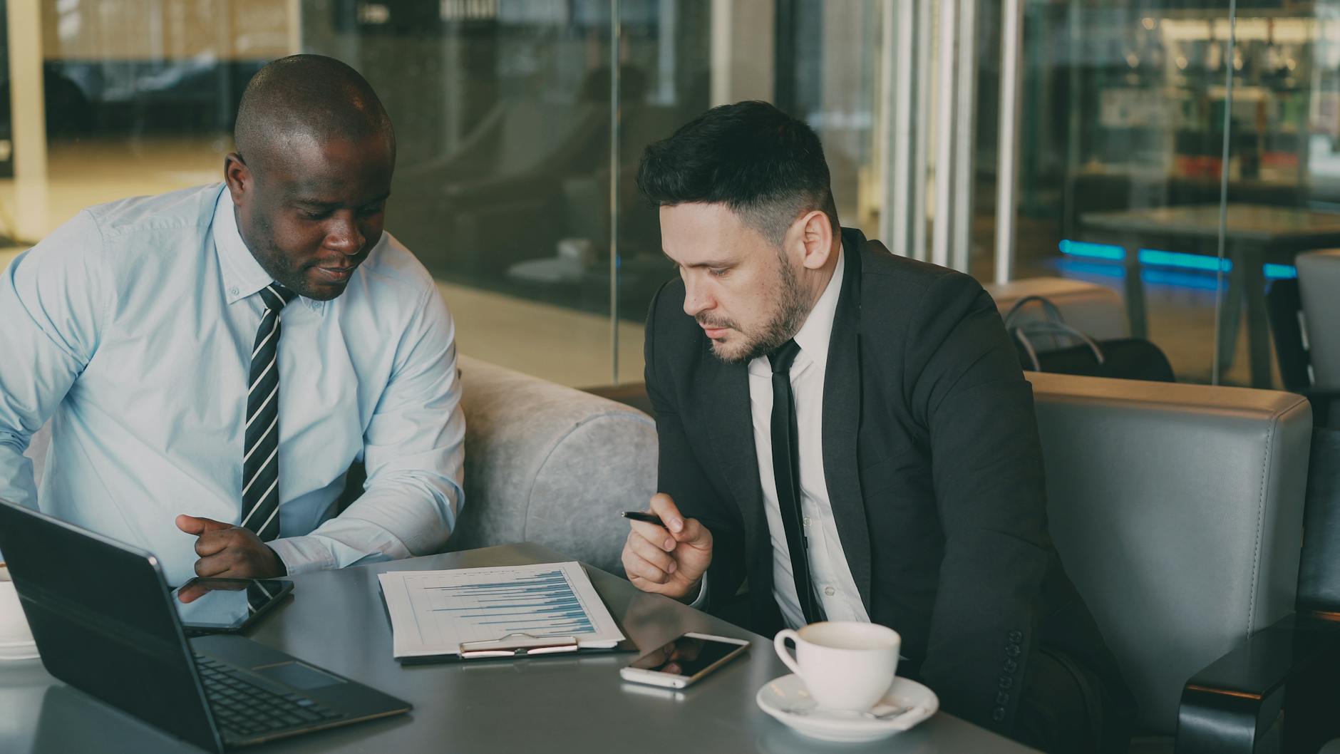 Business professionals reviewing a financial report for consultant travel report planning.