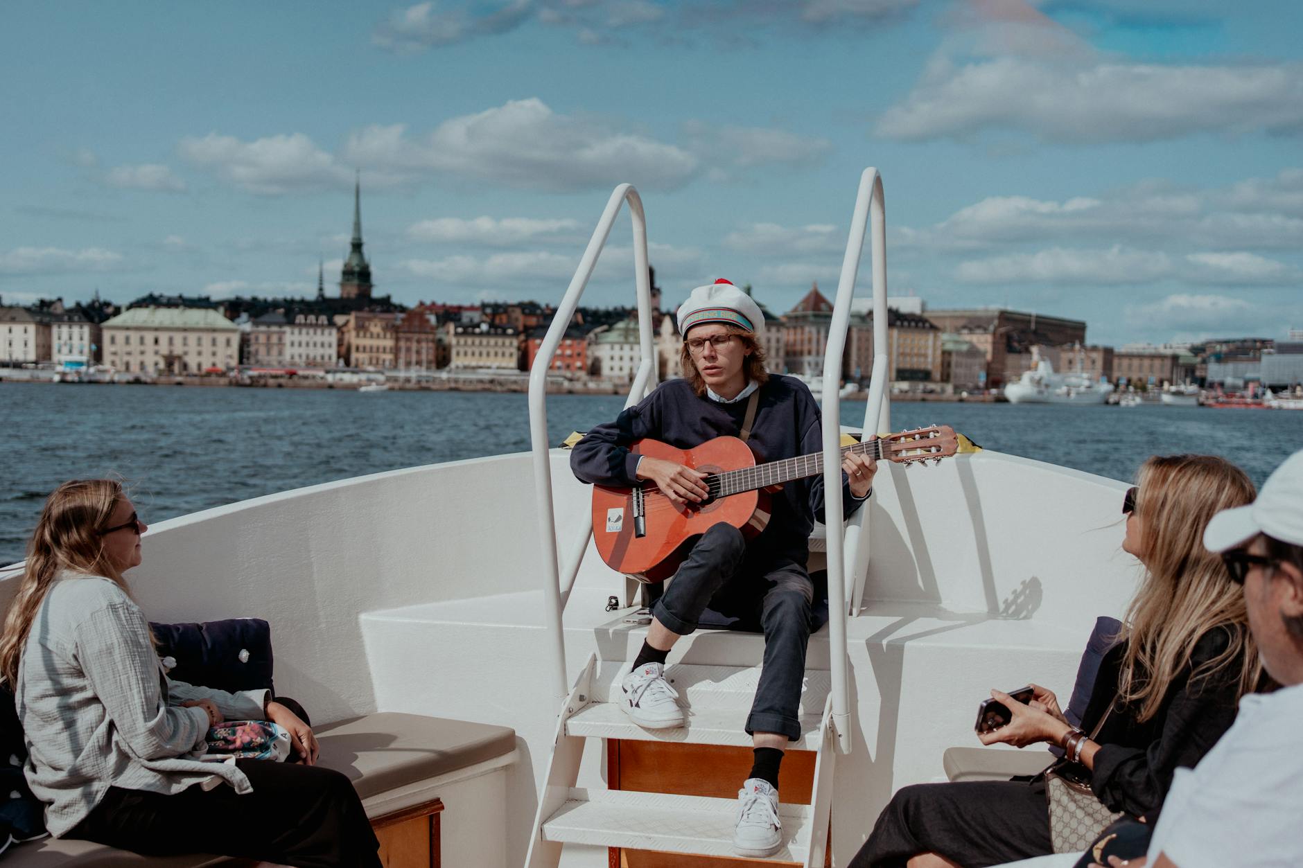Musician on a boat with Stockholm cityscape for creator posting and recovery planning.