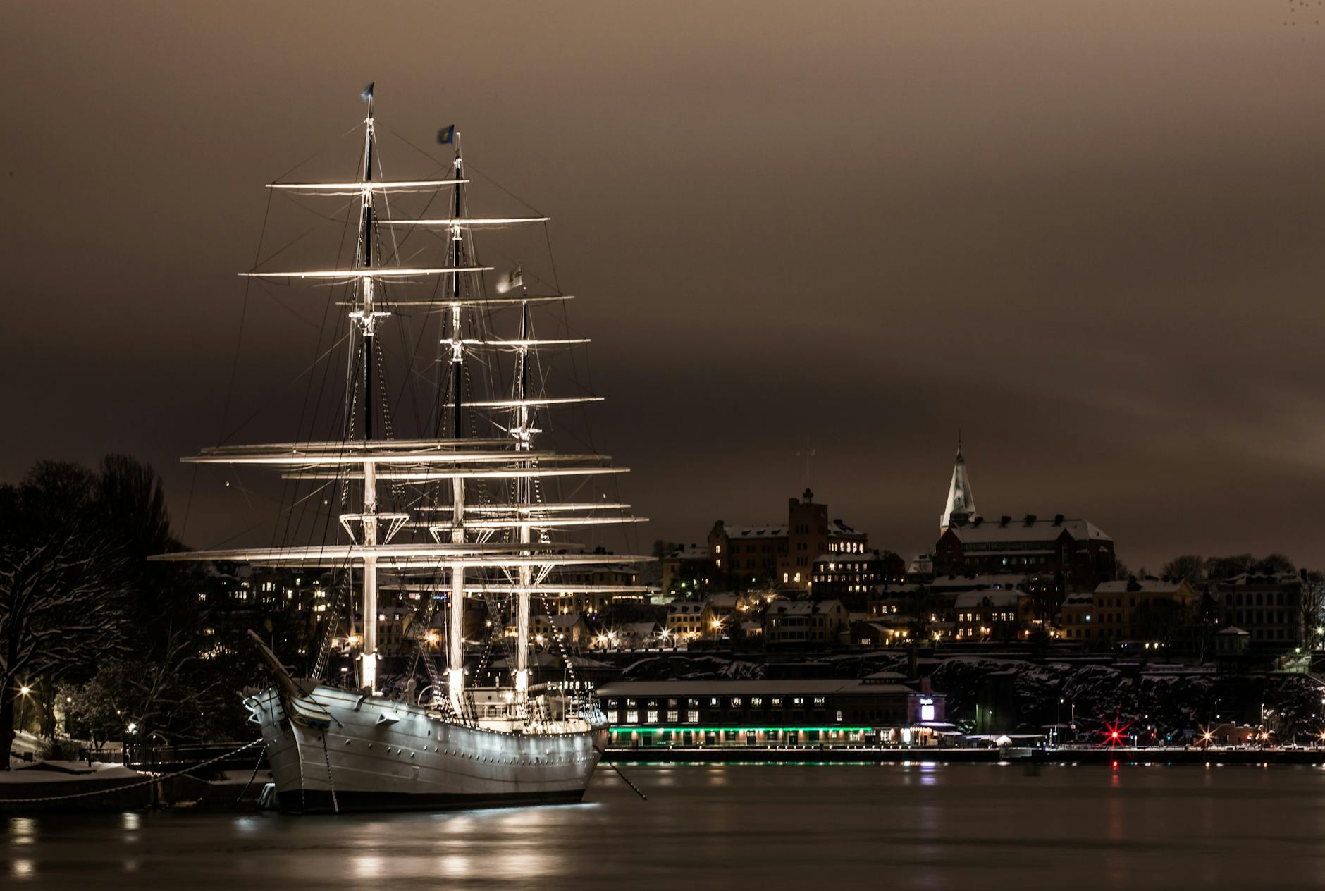 Illuminated Stockholm harbor sailboat for cruise travel report planning.