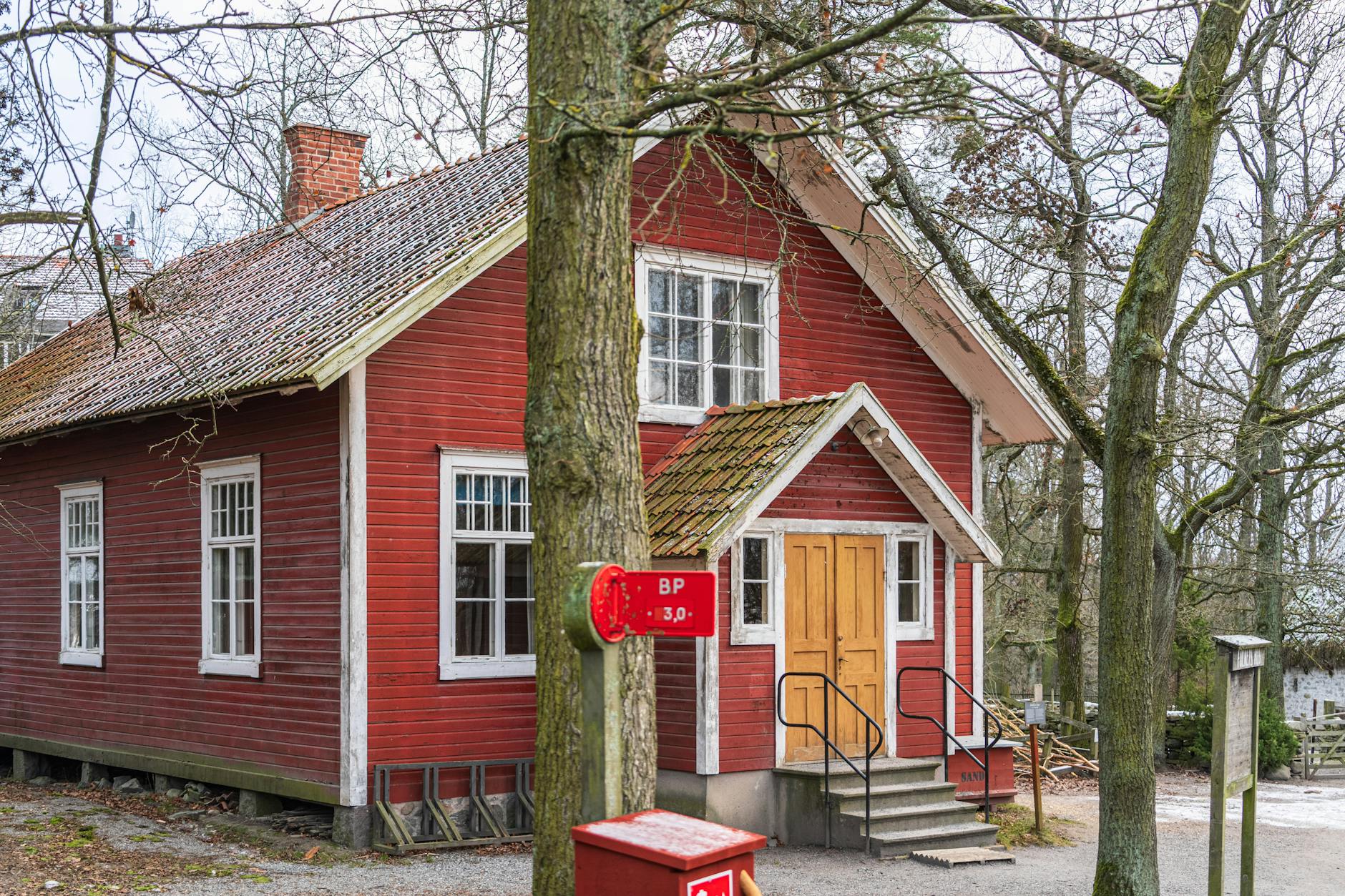 Red wooden house in a Stockholm open-air setting for family weather backup planning.