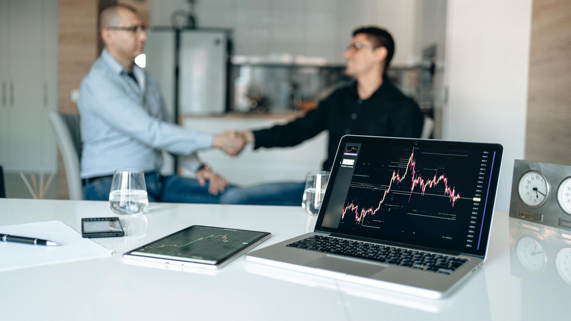 Deal-team handshake with financial charts for Stockholm travel report planning.