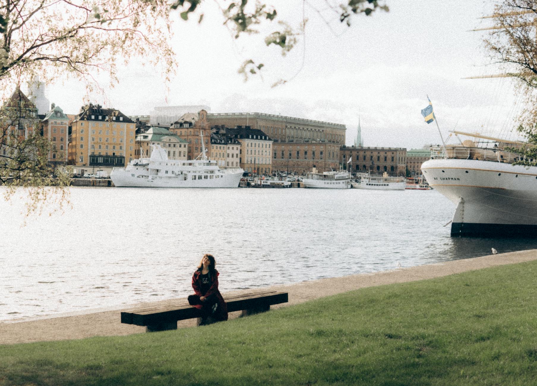 Older woman sitting near water for Stockholm older-traveler planning.