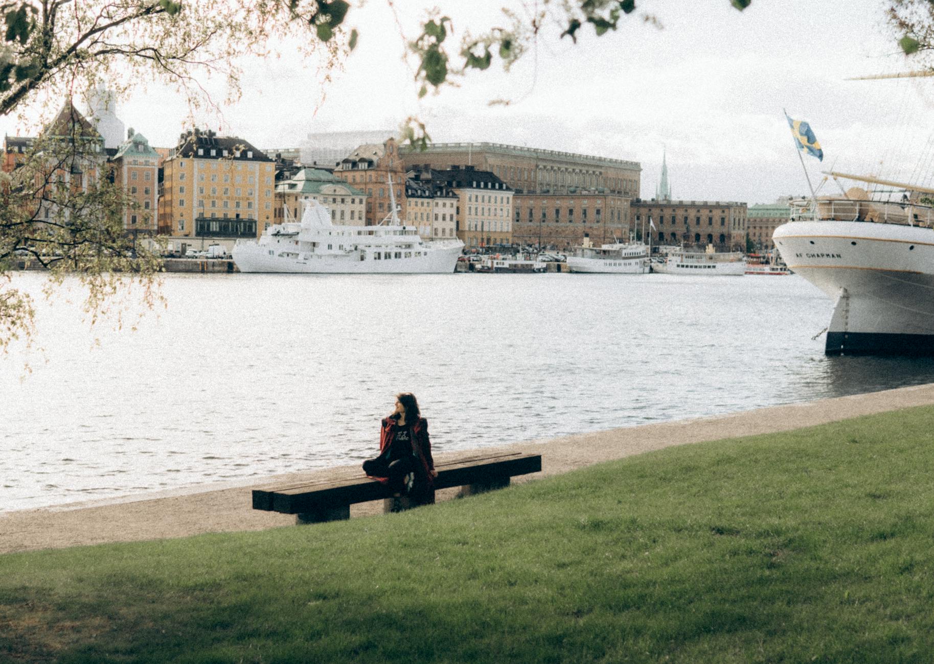 Person sitting by Stockholm waterfront for solo pacing planning.