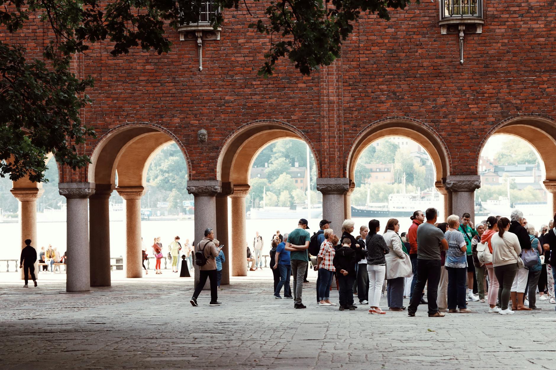 Tourists under Stockholm arches for weather-aware sightseeing planning.