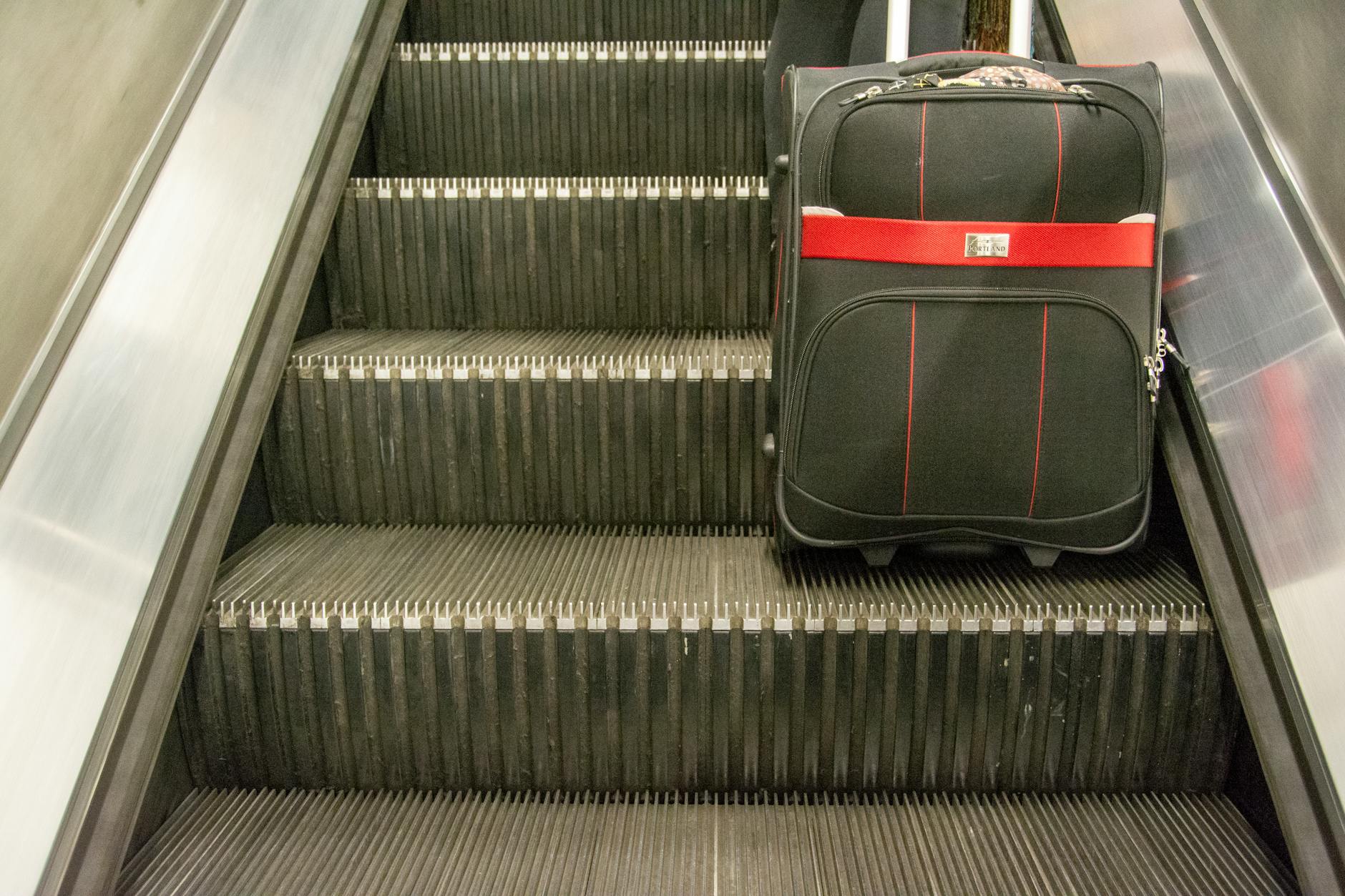 Suitcase on escalator for Stockholm transit travel report planning.