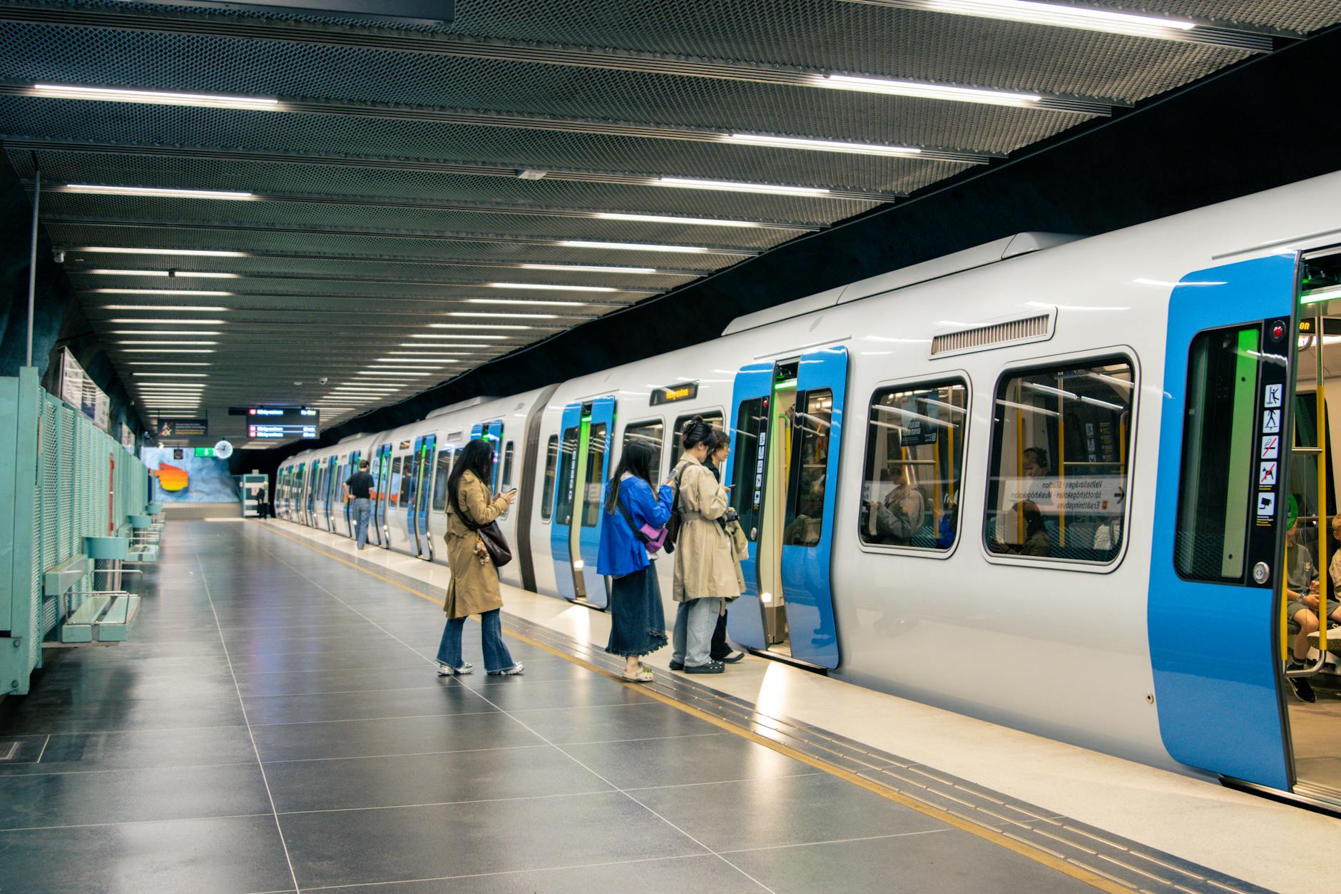 Commuters at Stockholm metro platform for stopover pacing planning.
