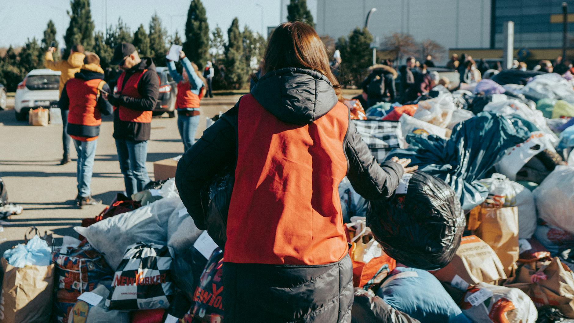 Volunteers sorting clothing donations for NGO travel preparation.