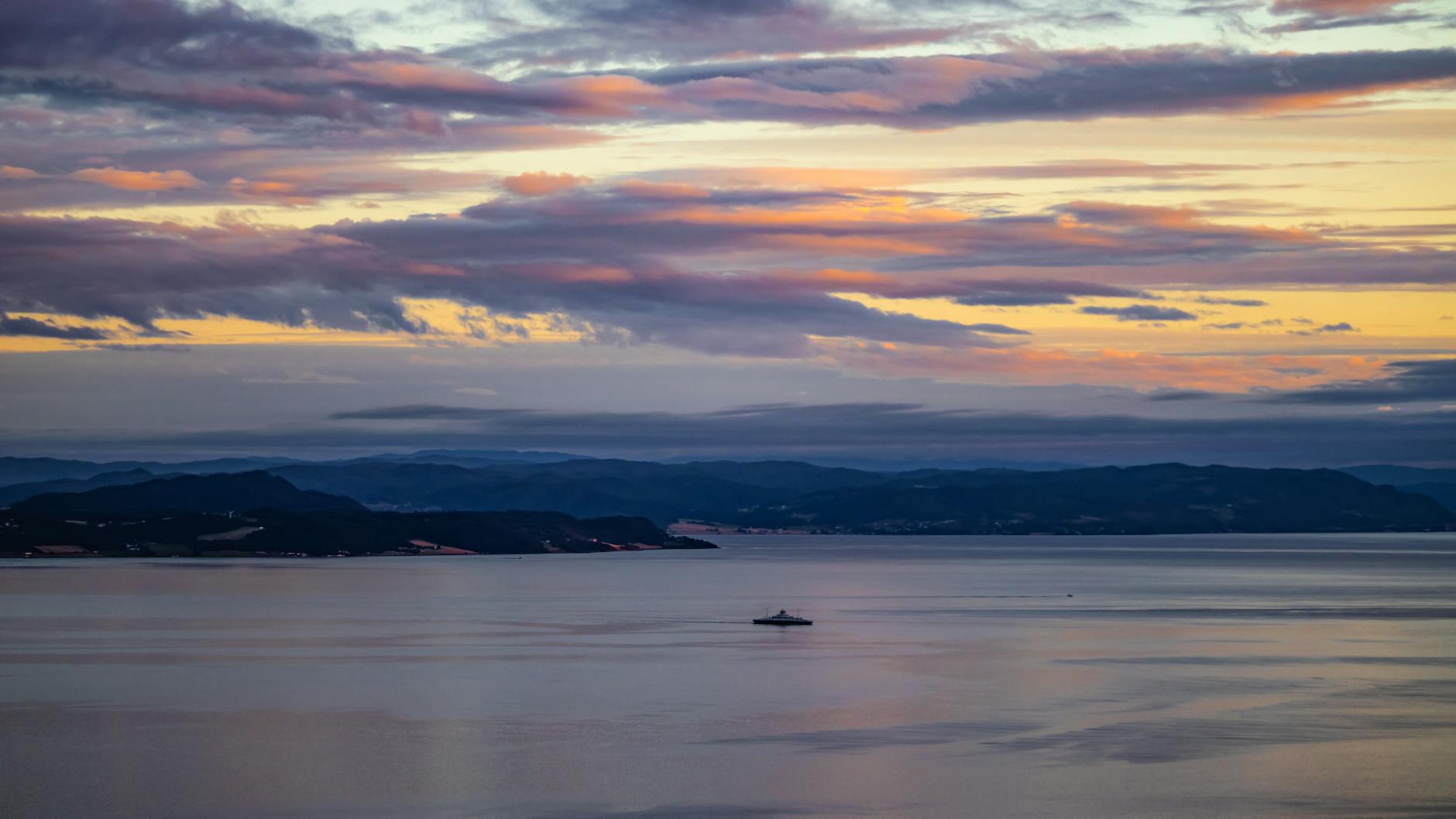 Sunset over a fjord for Trondheim tourist landmark and river planning.