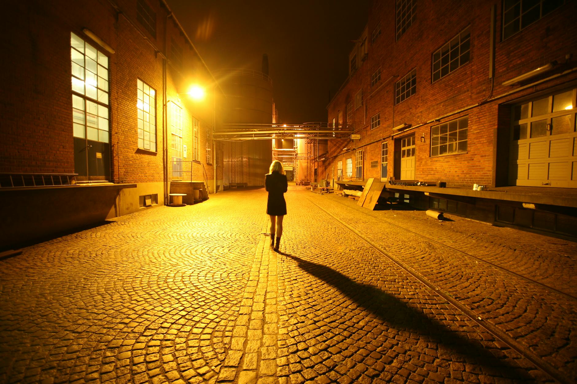 Woman walking on a cobblestone street for Trondheim route planning.