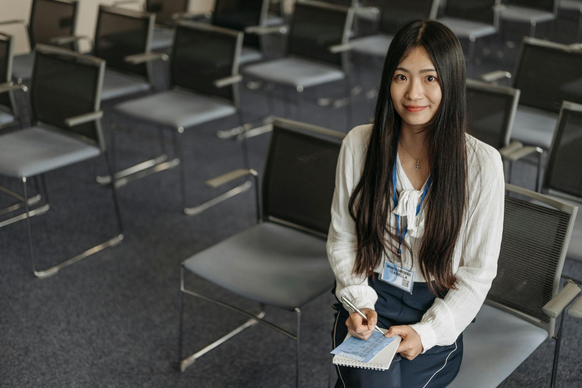 Woman with notebook sitting in an empty conference room