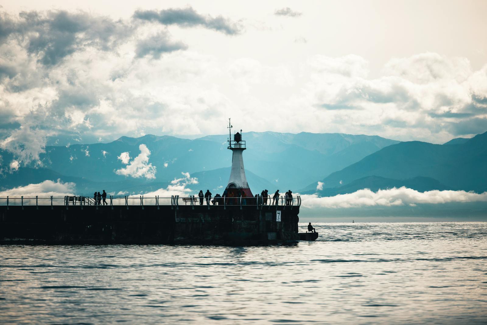 Lighthouse with mountains and ocean in Victoria, BC, Canada.