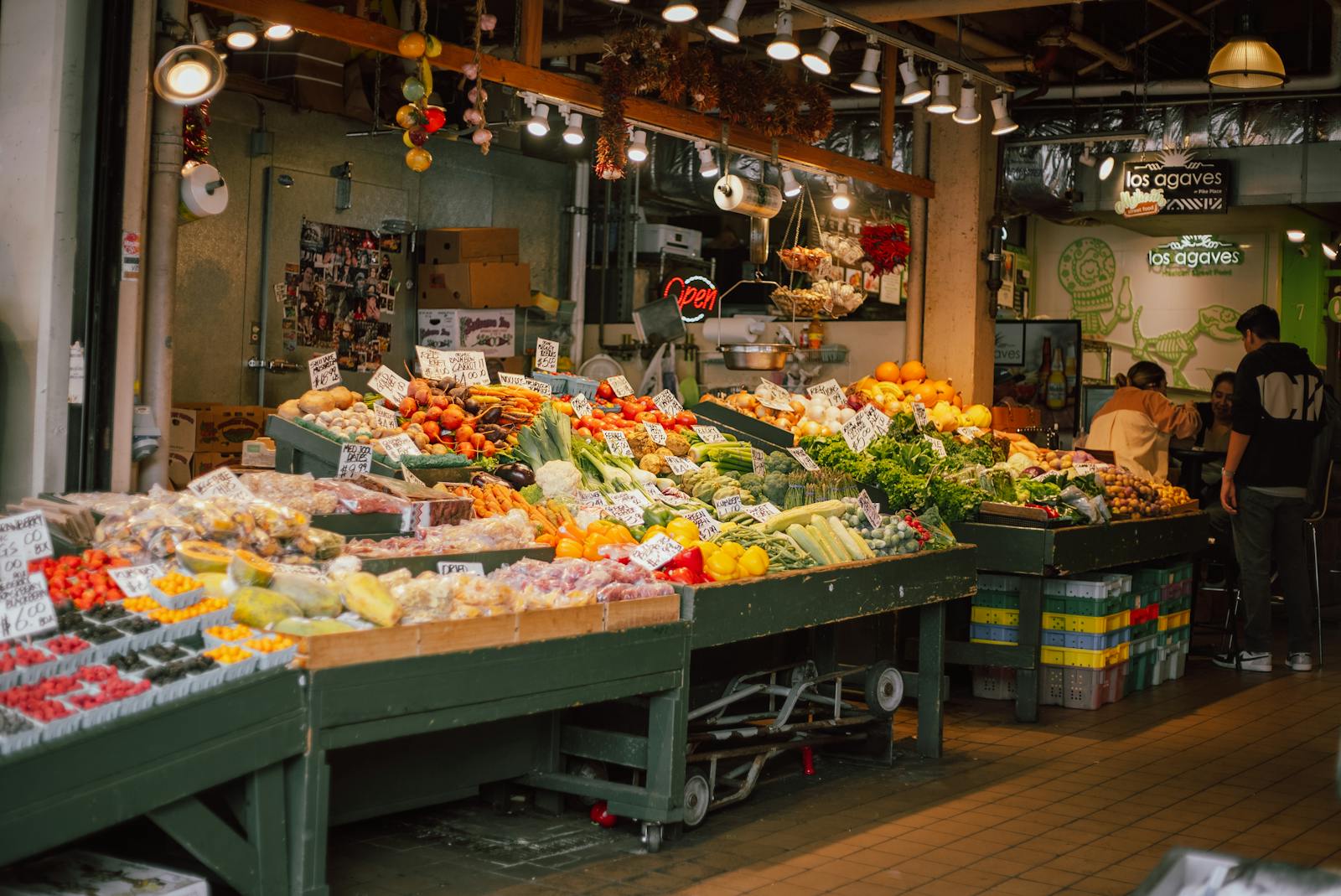 Colorful indoor market stall with an array of fresh fruits and vegetables on display.