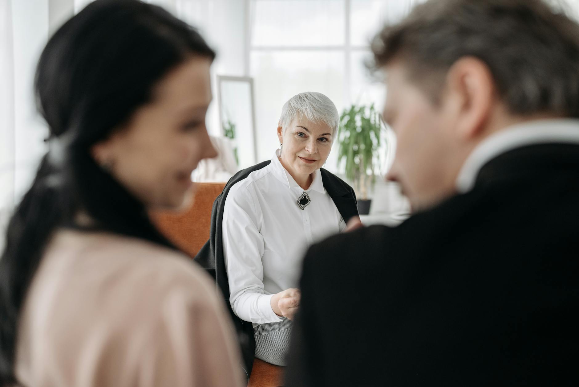 A professional consultation session with a couple and a social worker in a modern office environment.