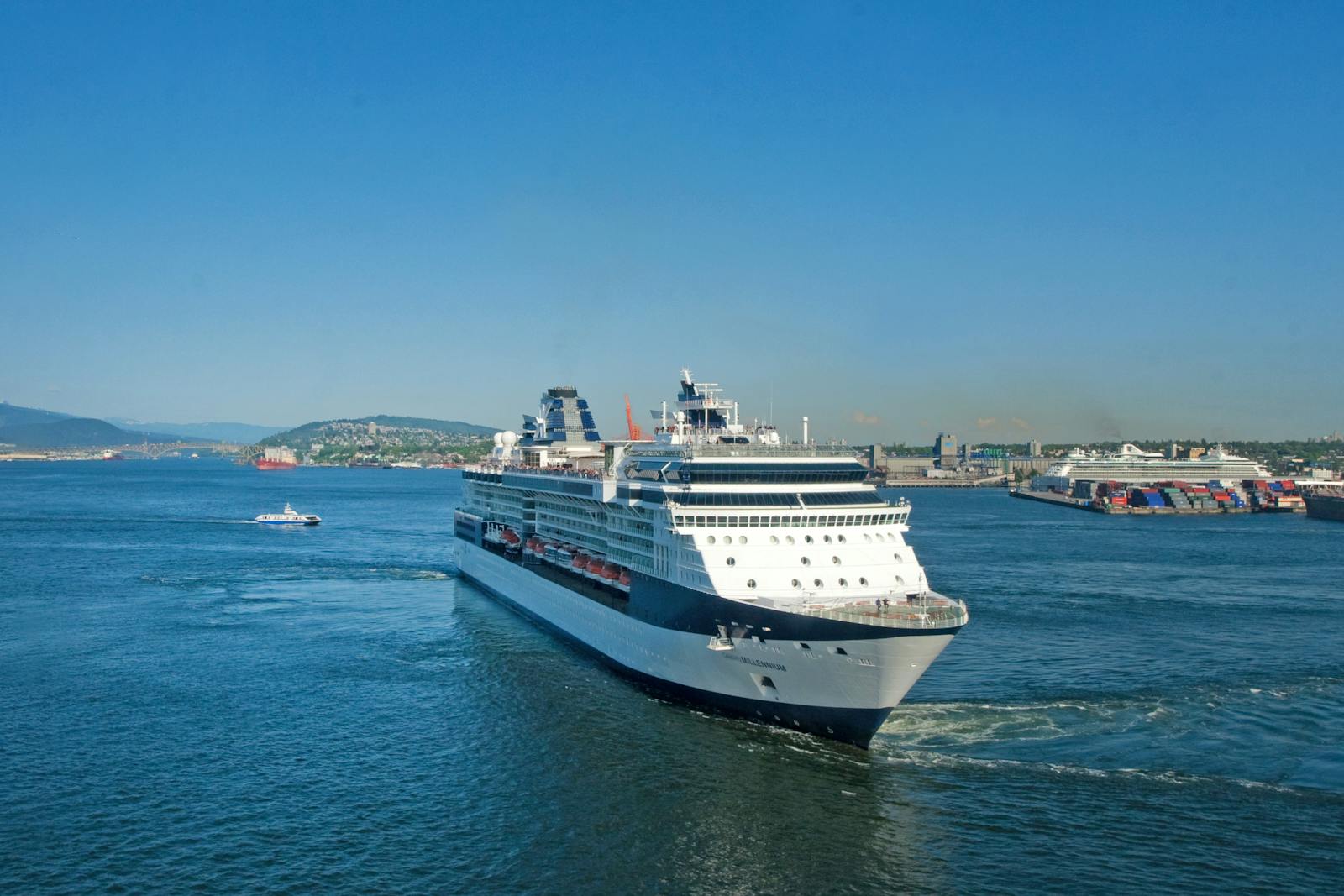 Large cruise ship sailing through calm waters under a clear blue sky.