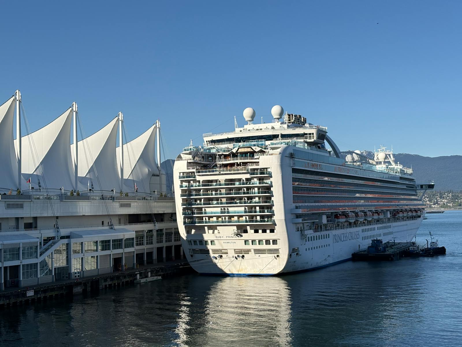 Cruise ship docked at Canada Place in Vancouver with iconic sails and harbor views.