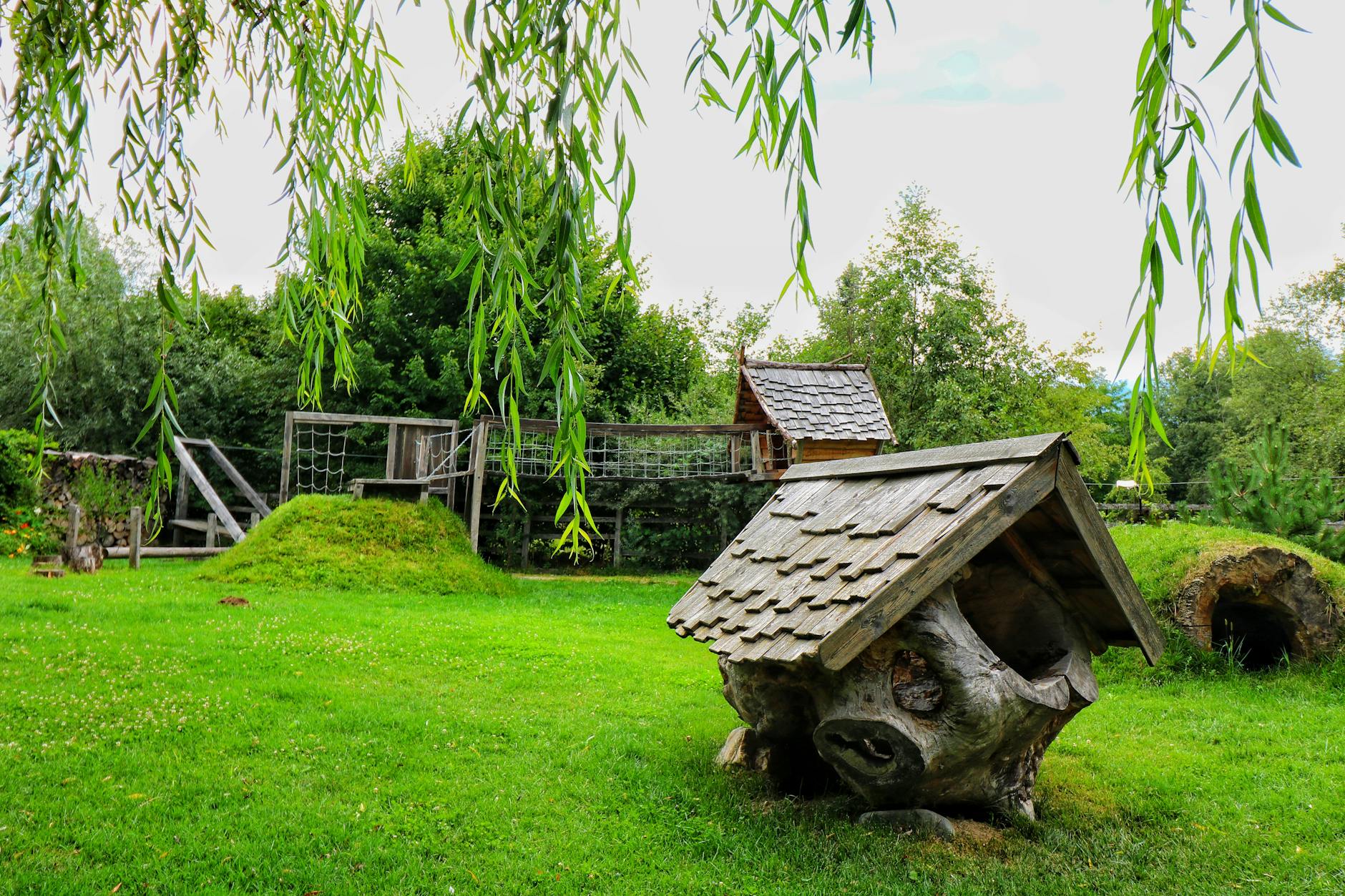 Rustic playground with wooden structures surrounded by greenery