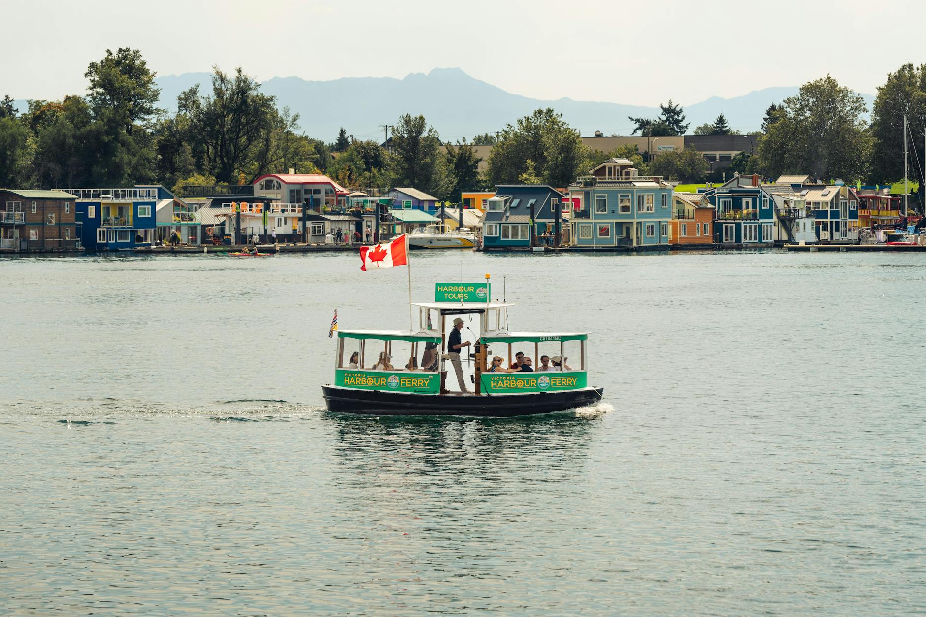 Victoria Inner Harbour ferry tour with colorful houseboats and mountains