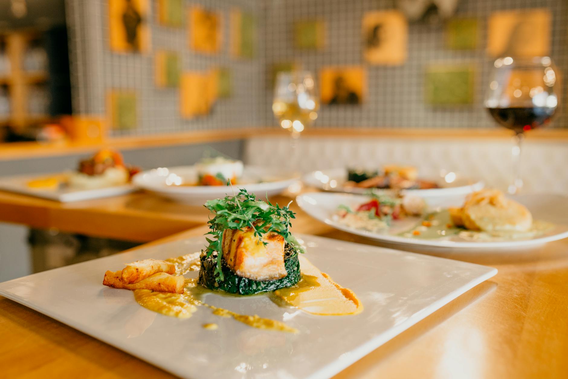 Restaurant table with plated dishes and glasses of wine