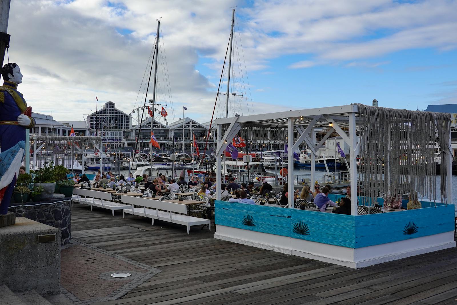 People enjoying a vibrant dining experience at a bustling waterfront marina.