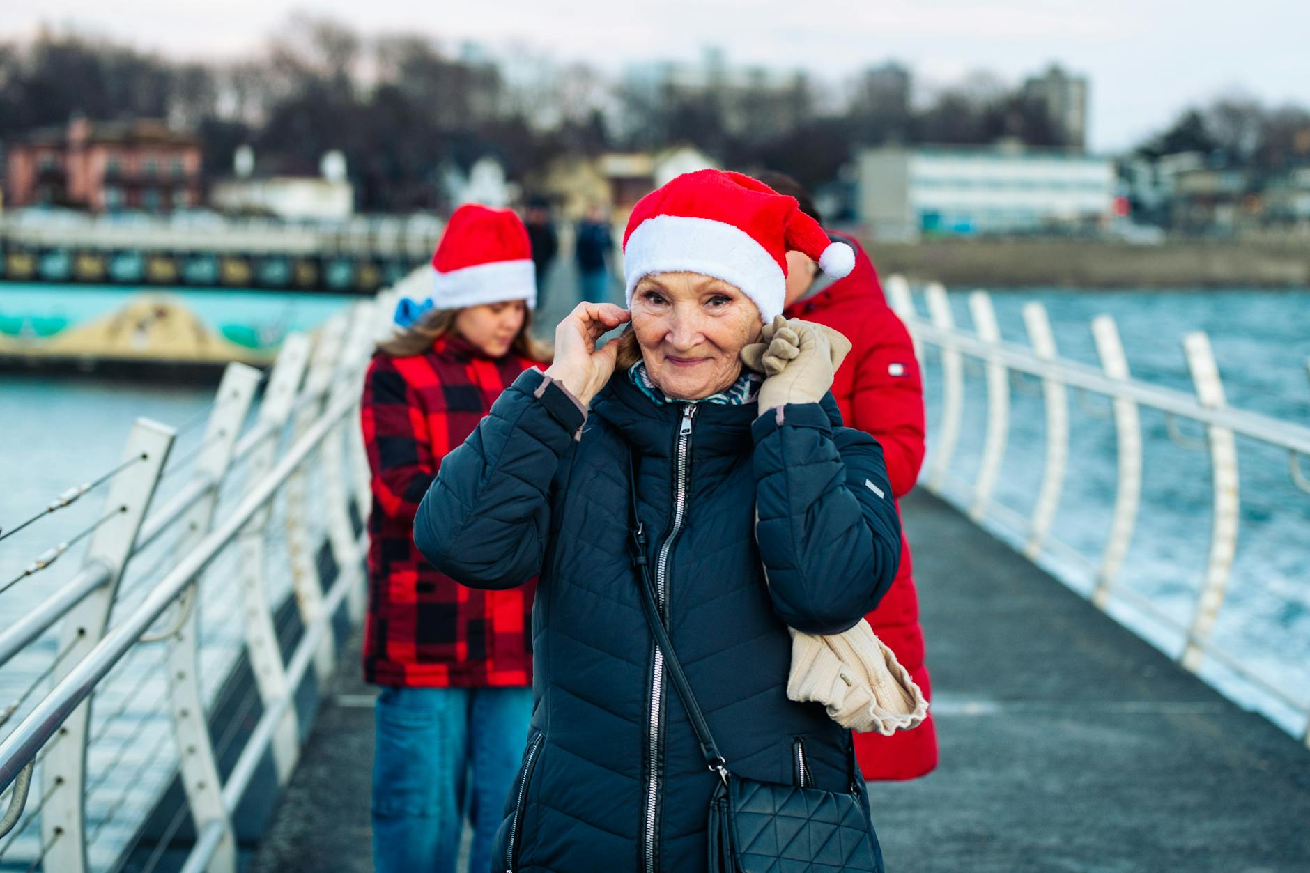 Older traveler and family walking along the Victoria waterfront in winter