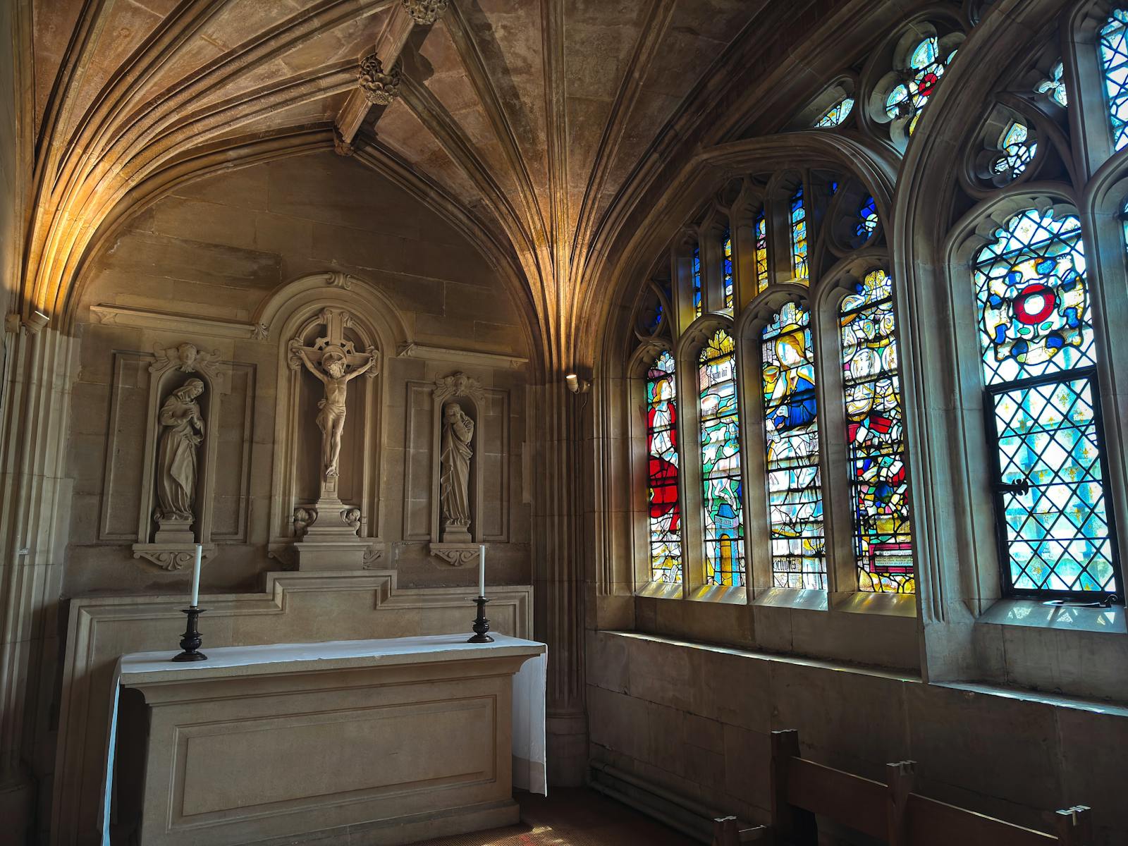 Serene Gothic chapel interior with stained glass windows and intricate stone carvings.