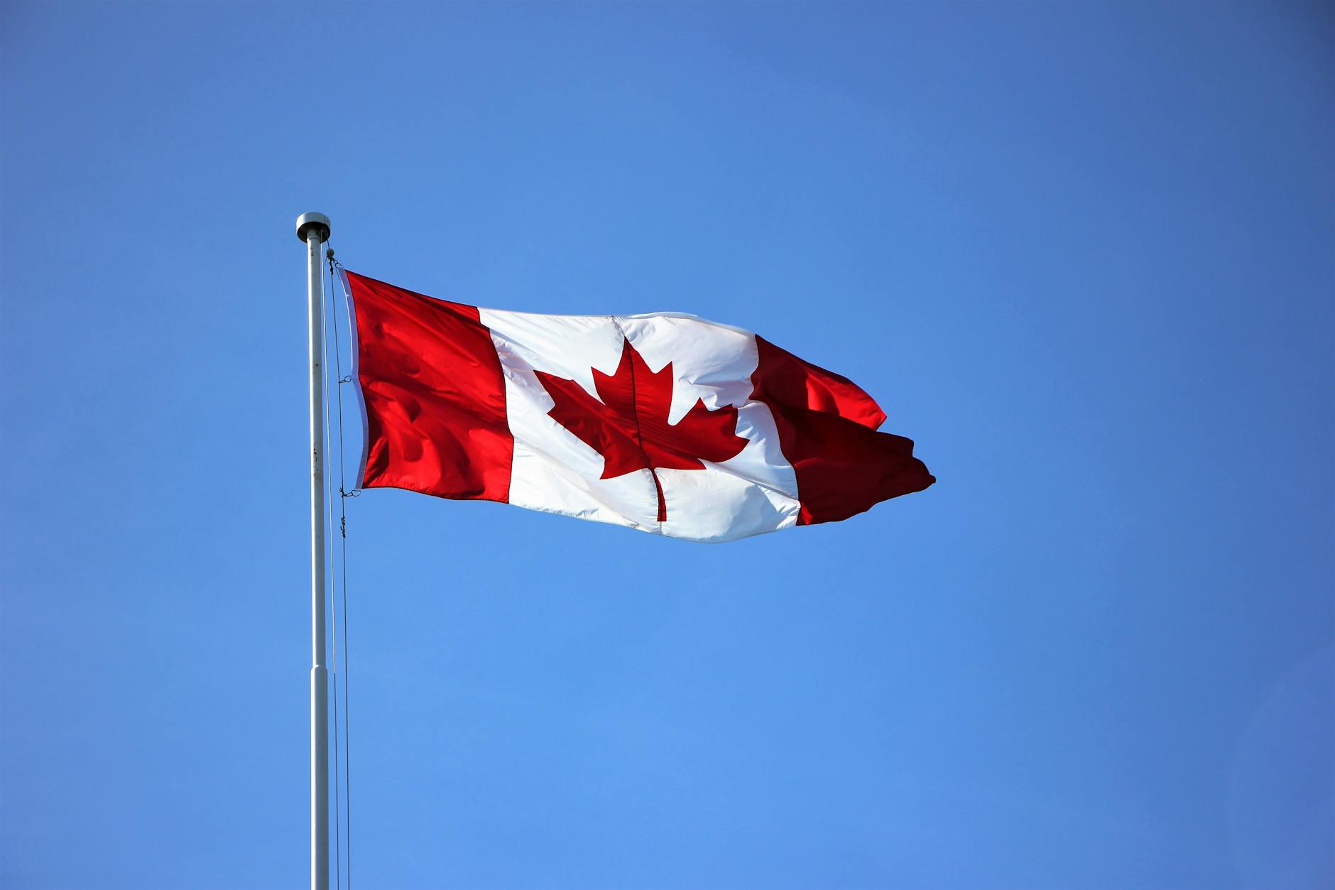 Canadian flag against a clear blue sky in Victoria