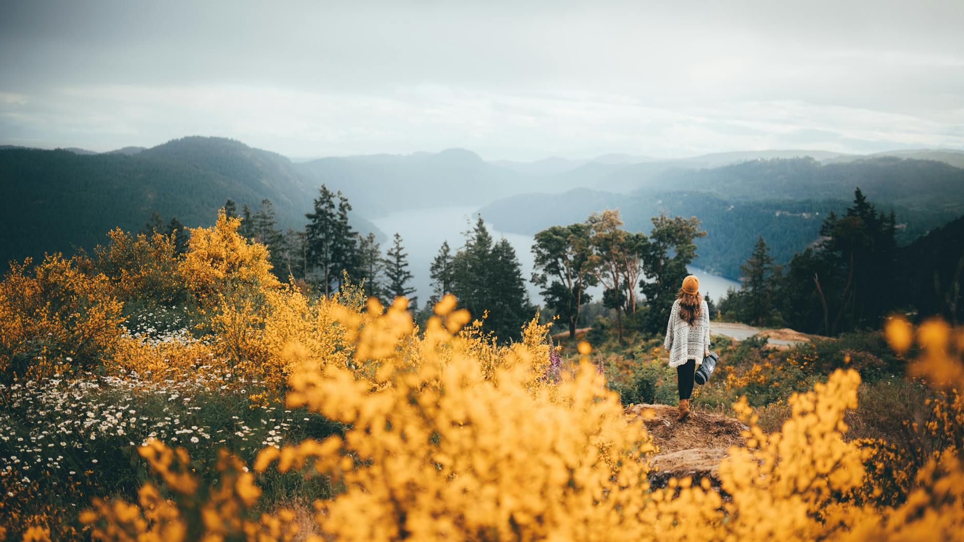 Hiker overlooking fall foliage and a lake in Victoria