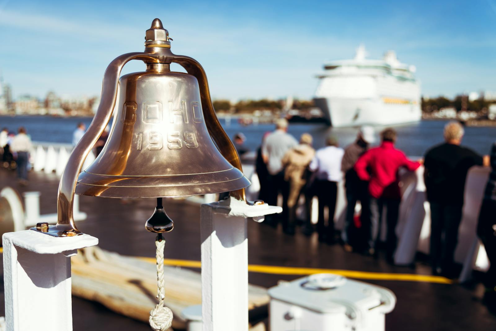 Clear view of a cruise ship with a bell in the foreground on a sunny day.
