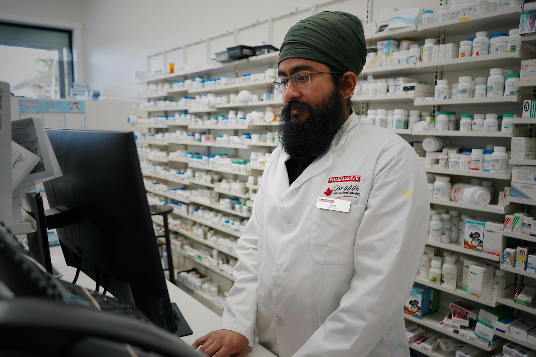 Pharmacist working at a computer in a pharmacy