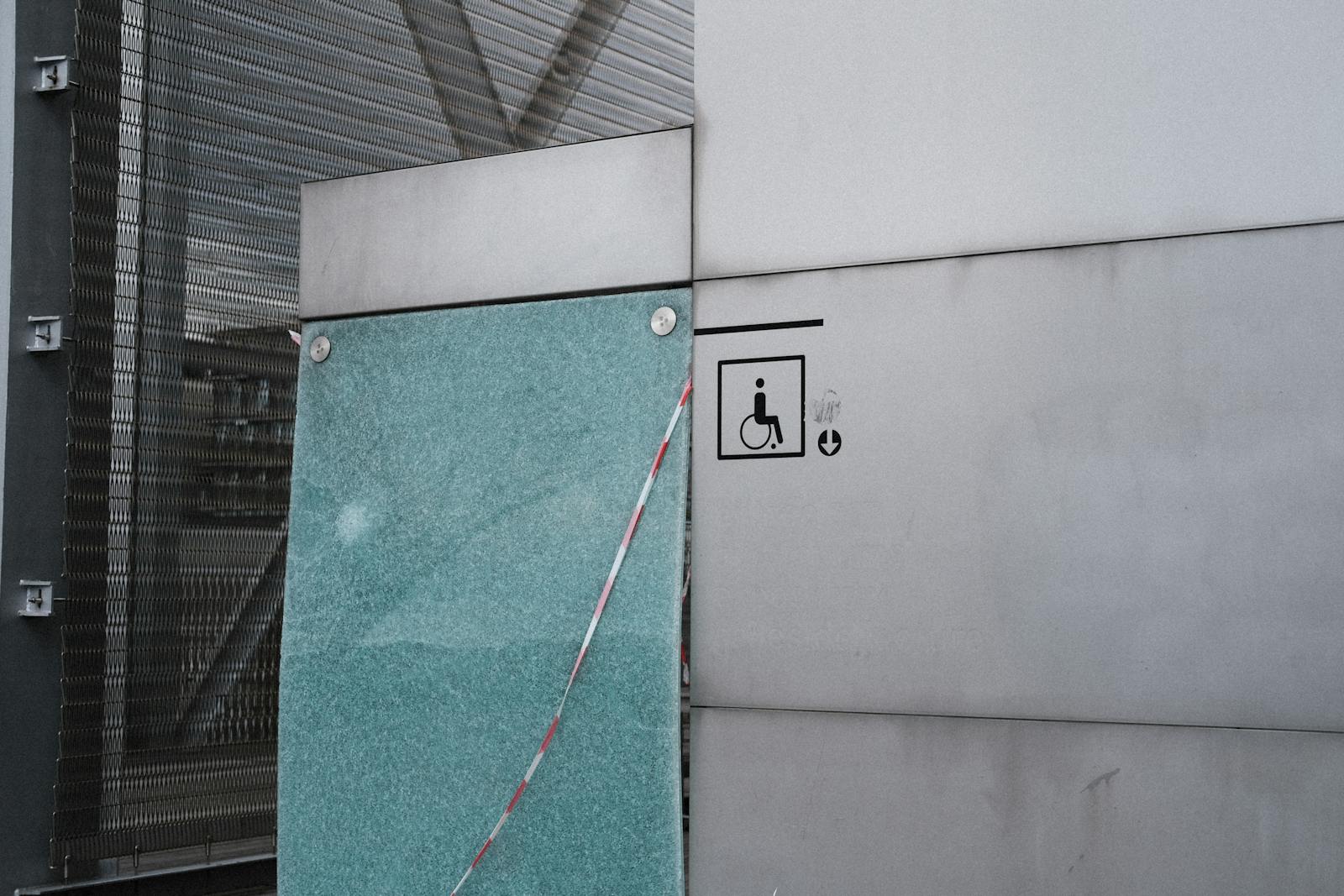 Urban architectural facade featuring an accessibility symbol for wheelchair access.