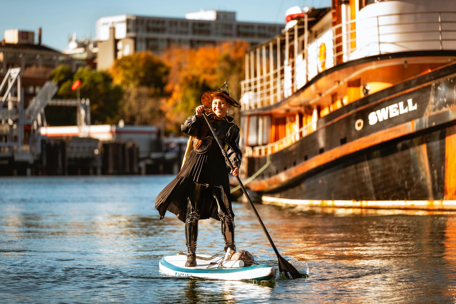 Woman paddleboarding near a historic ship in Victoria Harbour