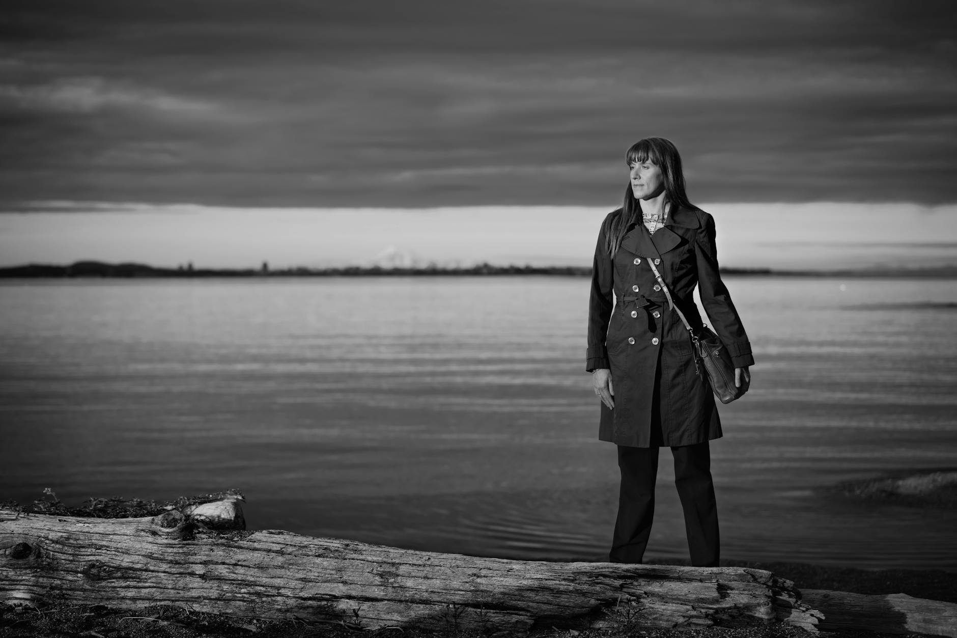 Woman standing by the ocean in grayscale