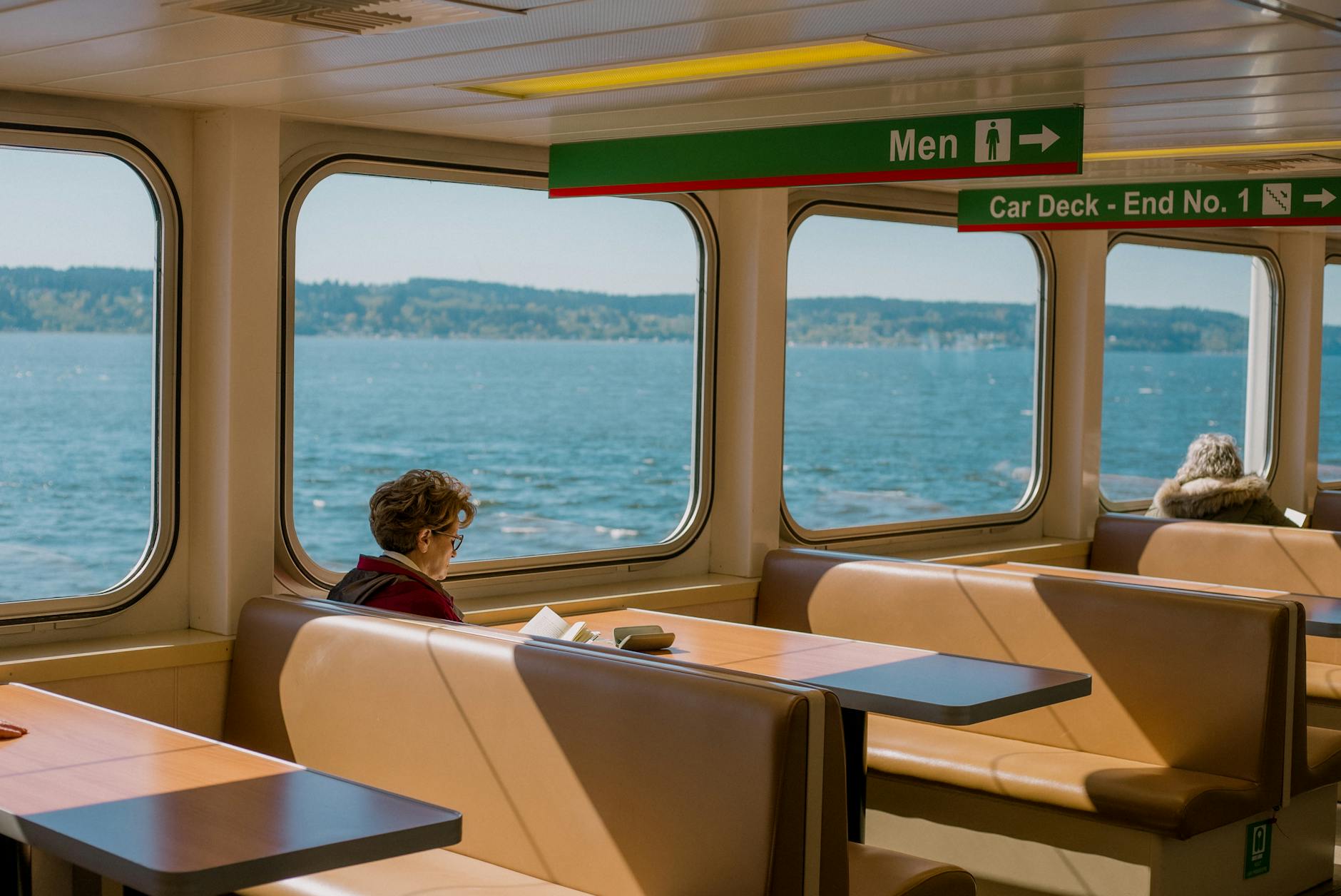 Woman reading on a ferry with ocean views