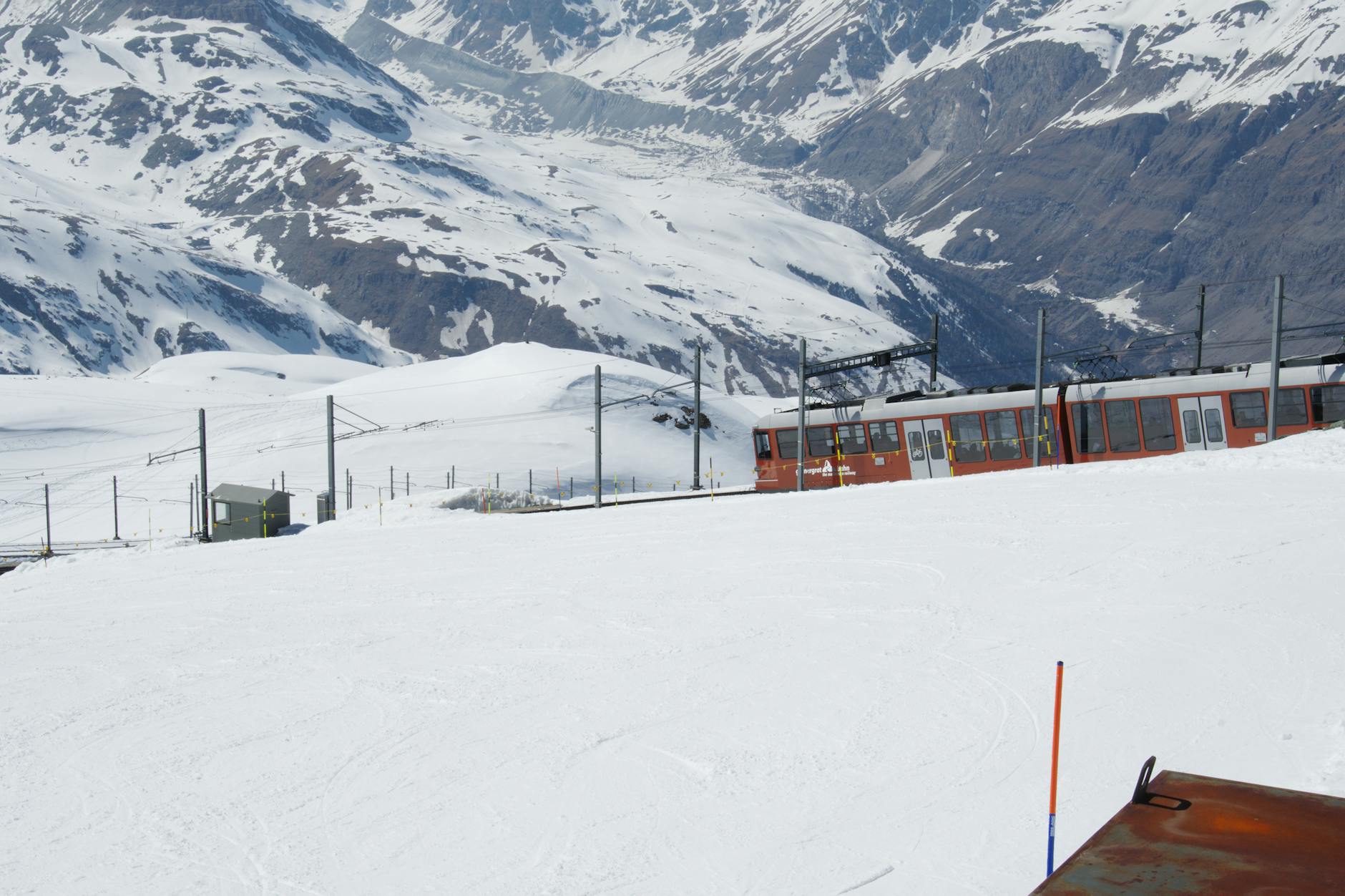 Red train at Gornergrat station for Zermatt conference movement planning.