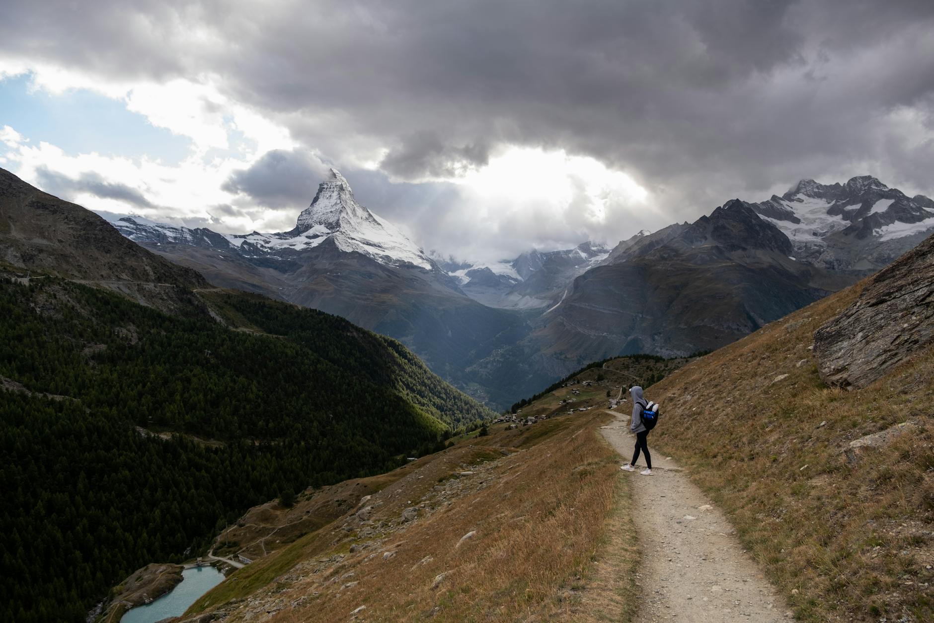 Woman with backpack in alpine terrain for Zermatt hotel and route planning.