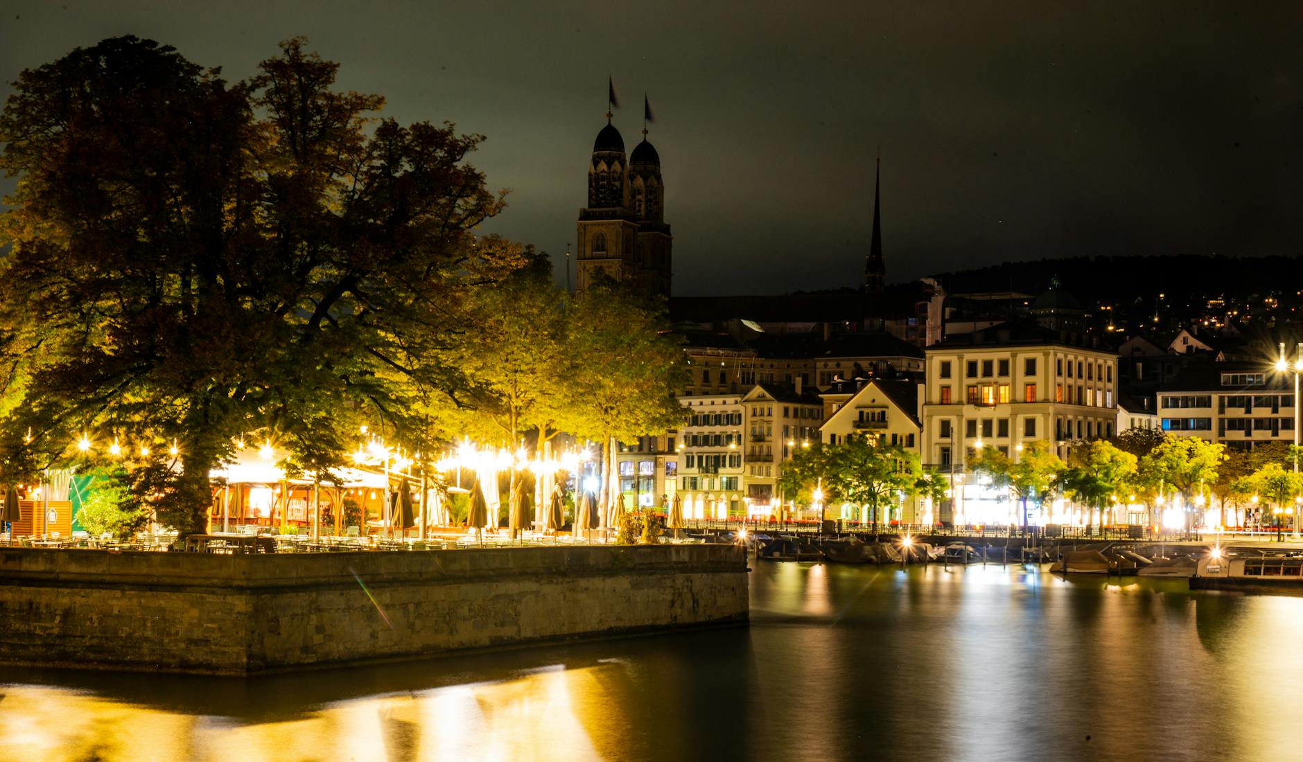 Zurich illuminated night street and Grossmunster context for nightlife planning.
