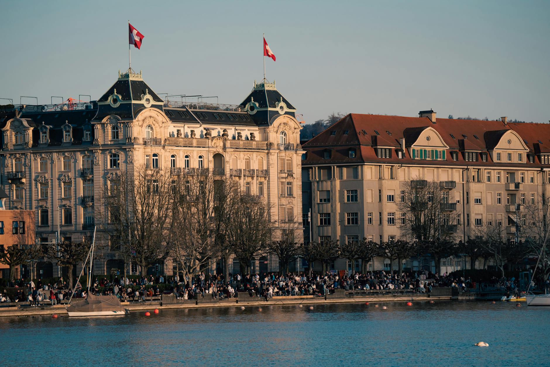 Zurich waterfront and Swiss flags context for comfort-focused spending decisions.