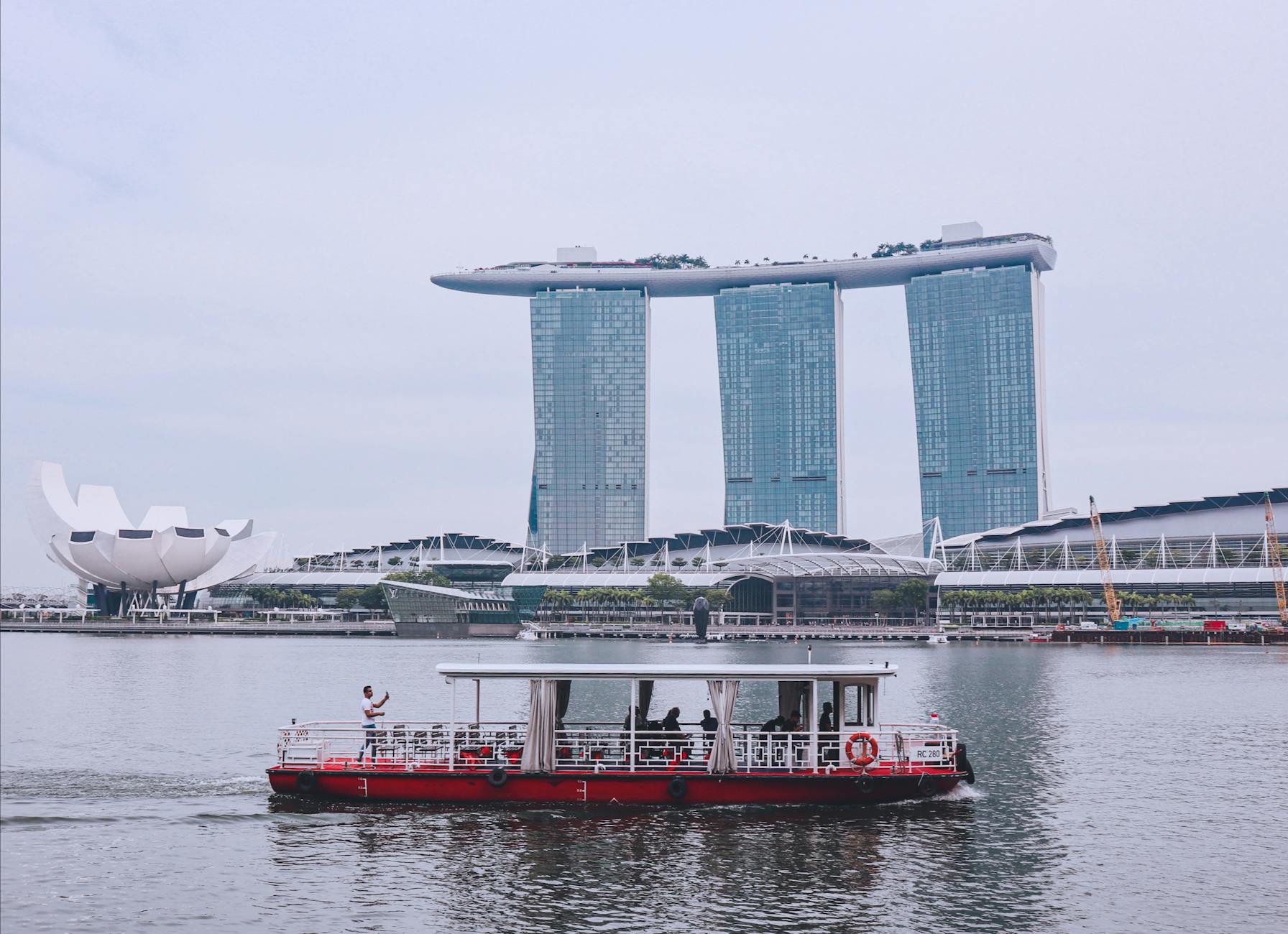 Riverboat crossing Marina Bay with the skyline behind.