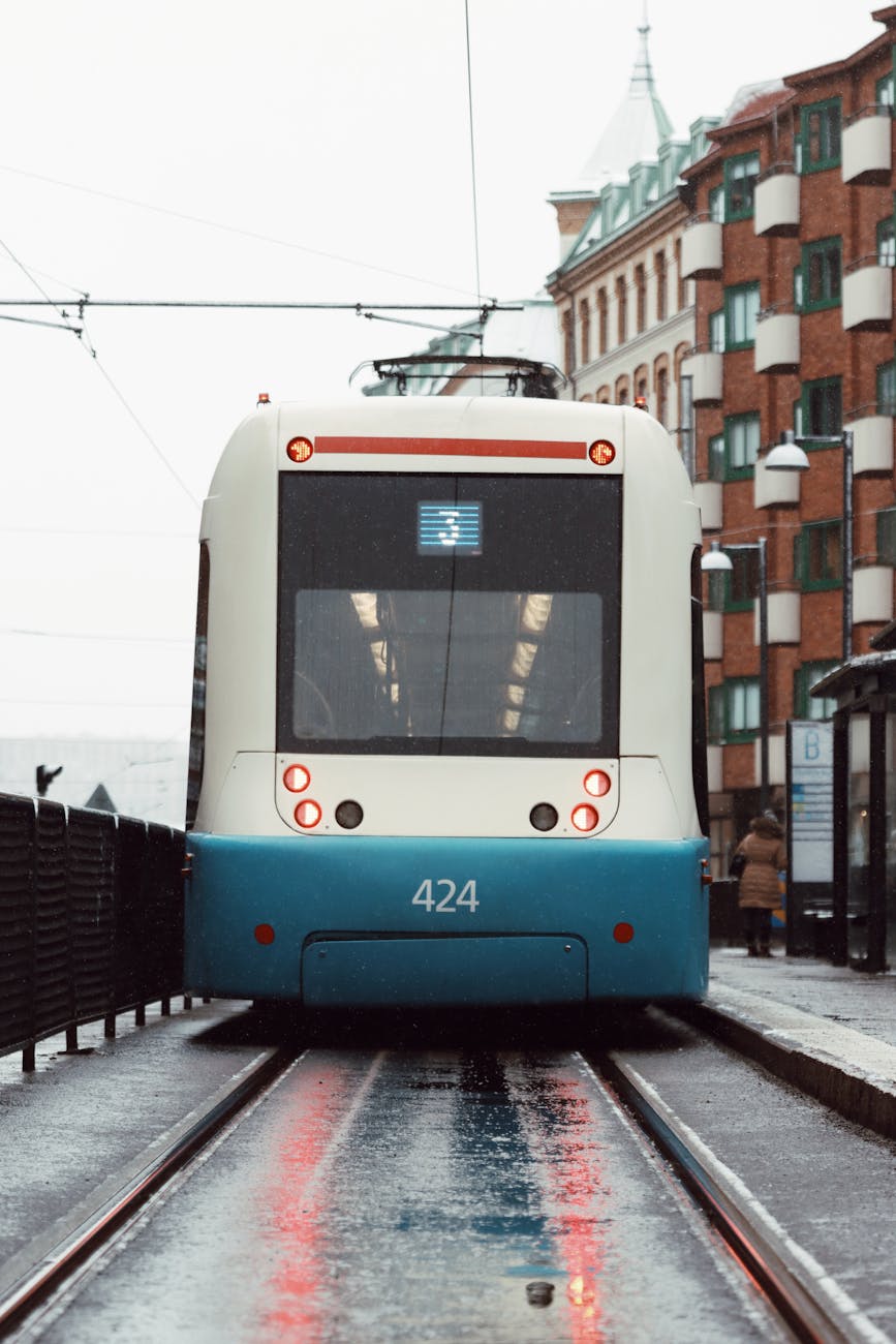 Blue tram at a Gothenburg station in the rain.