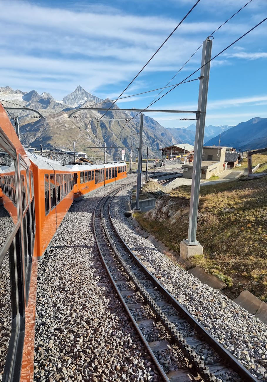 Orange train traveling through the Swiss Alps near Zermatt.