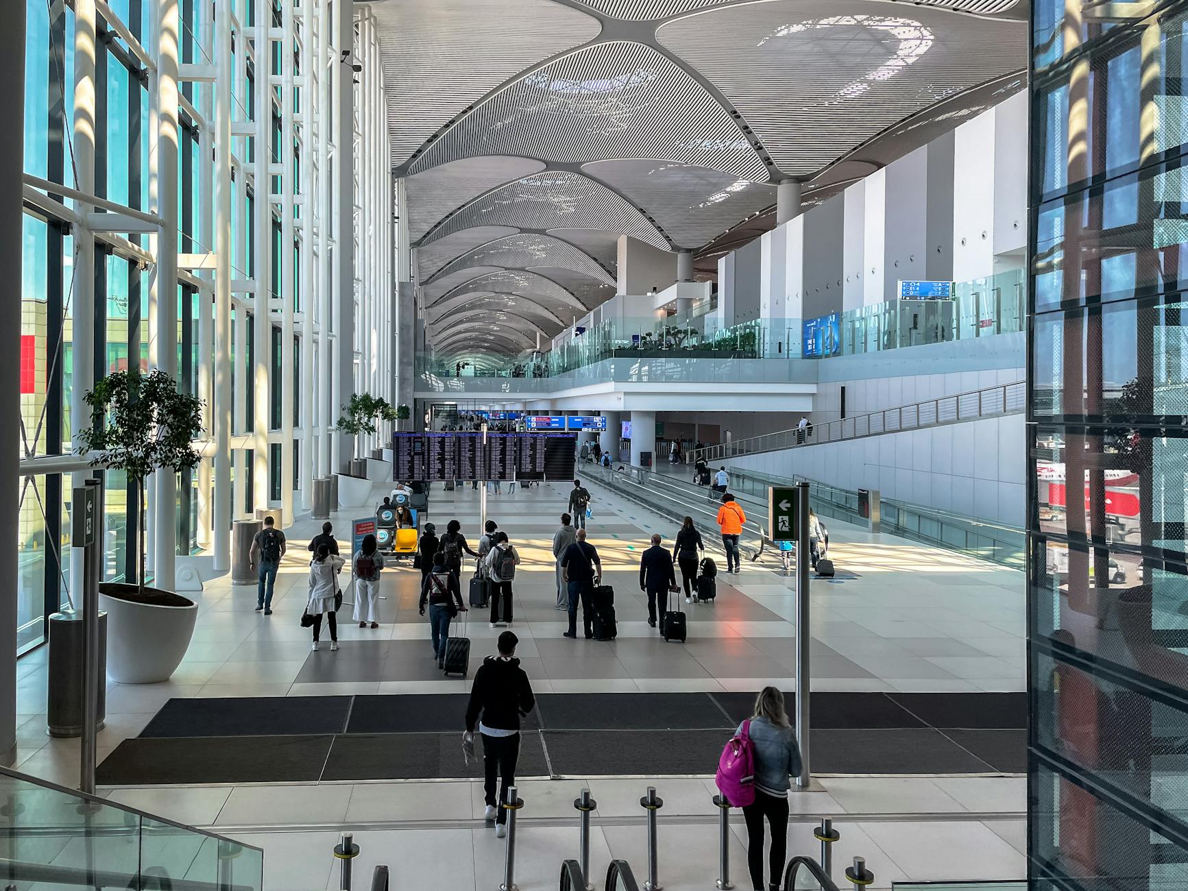 Travelers inside a modern Turkish airport terminal.