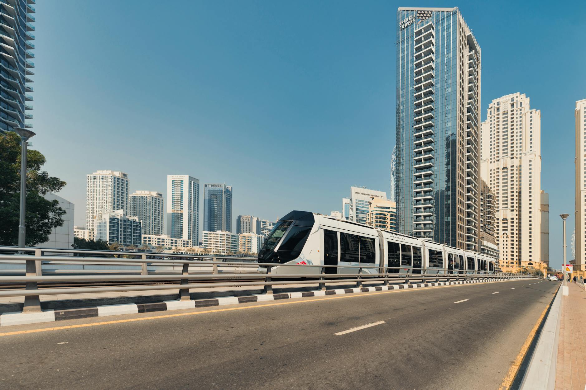Dubai Metro train running beside high-rise towers.